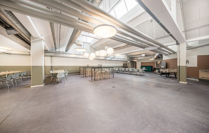 En stor, moderne mødelokale med højt til loftet, store vinduer og en stor, åben stue.