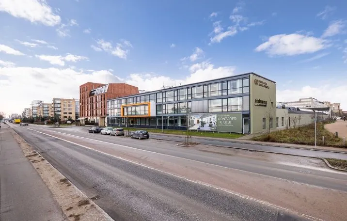 En kontorvæg med reklame til leje, store glasruder og lyse gulve i en bygning