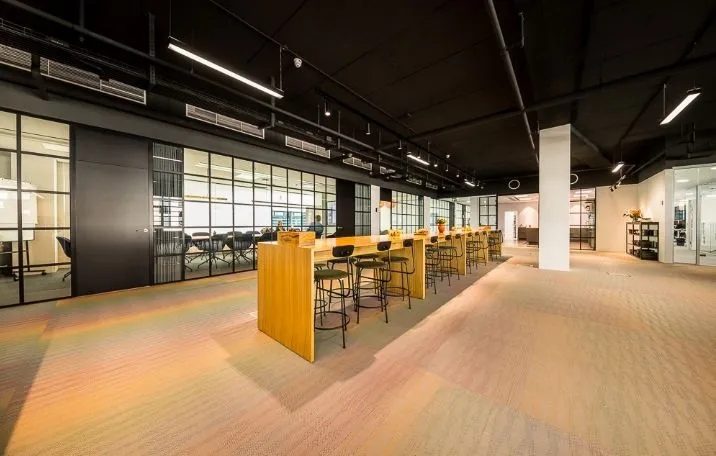 En moderne kontorbygning med gulv-til-loft-vinduer og møbler til arbejde i et åbent og lyserum