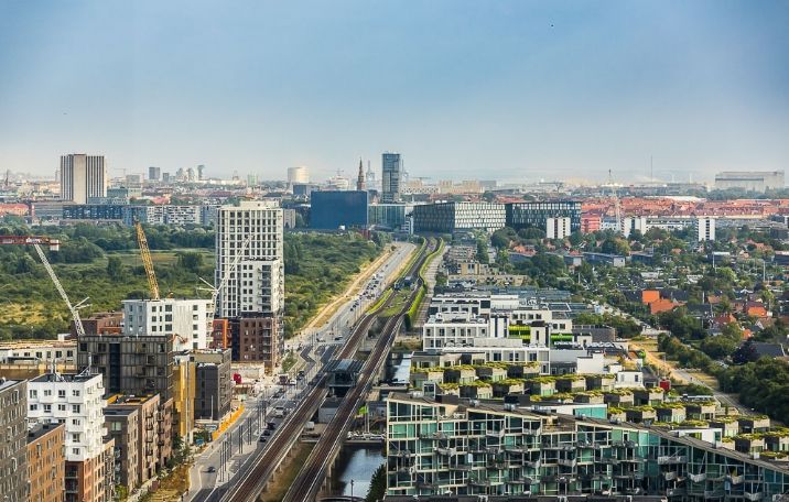 Stor by med mange højhuse og tætte gader under en klar og blå himmel