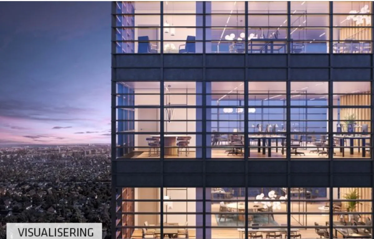 Moderne kontorbygning med gulv-til-loft-vinduer og udsigt over byen i aftenskumringen