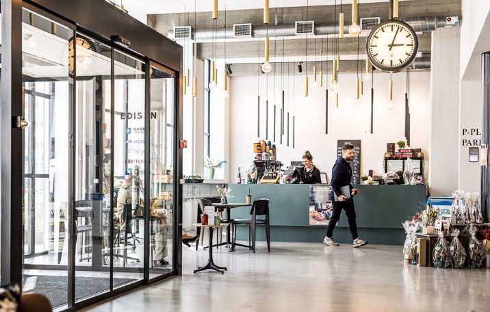 Flerbrugerhus med fælles kantine og mødecenter, sandblæste søjler og glasvægge i sort