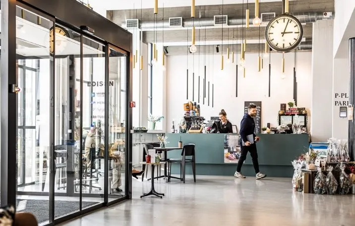 Flerbrugerhus med fælles kantine og mødecenter, sandblæste søjler og glasvægge i sort