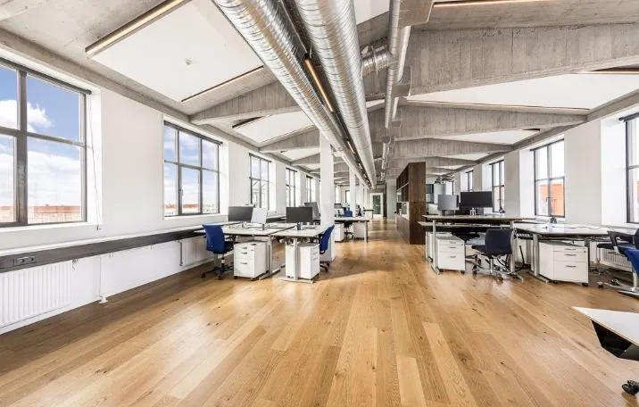 Kontor med højloft og lysevinduer med sandblæste søjler og møbler i moderne design