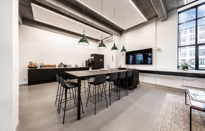 Moderne og minimalistisk kontor med sandblæste søjler, glasvægge, og store, komfortable møbler til ca. 50 arbejdspladser