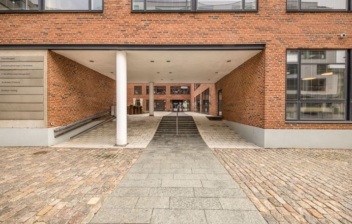 Opgang til kontorlokaler med skrappe linjer og lyse gulve, smukke røde mursten og moderne vinduer