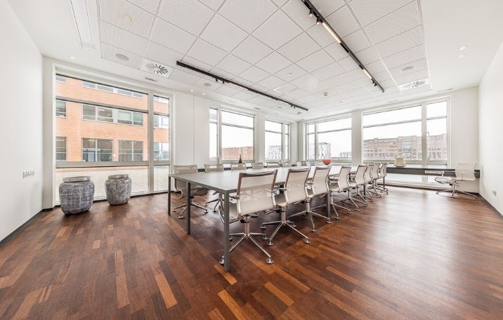 Elegant og funktionel mødelokale med store vinduer og moderne indretning