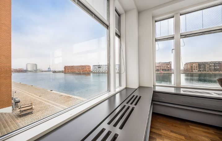 Kontorlokaler med havudsigt, moderne indretning, og vinduer med persienner og ventiler for god ventilation