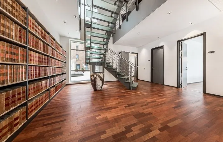 Kontorlokaler med højloft og trægulv, store vinduer, moderne bibliotek og glastrapper