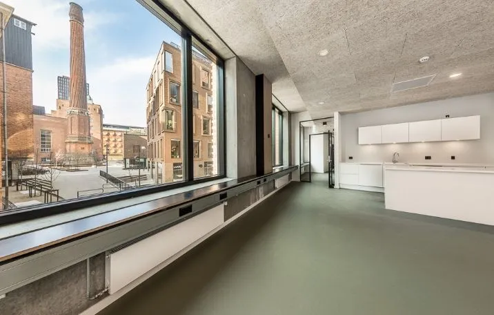 Kontor med udendørs udsigt og lyse gulve. Moderne funktionelt køkken med hvide hylder og højt loft. Værelse med vinduer med