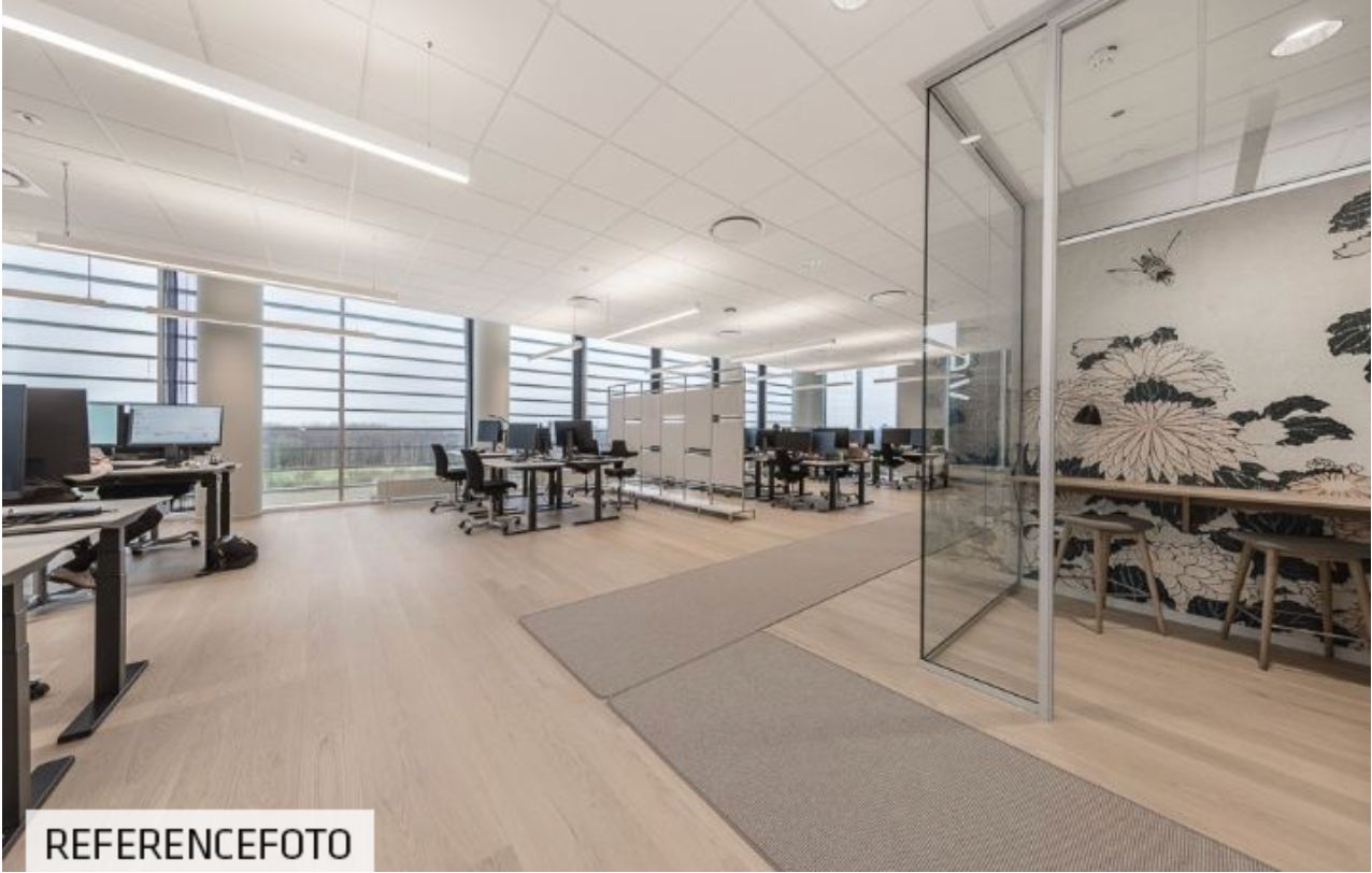 Moderne kontor med lyse lofter og gulve, skriveborde med computere, skyggefulde områder og smukke udsigtsvinkler til byen