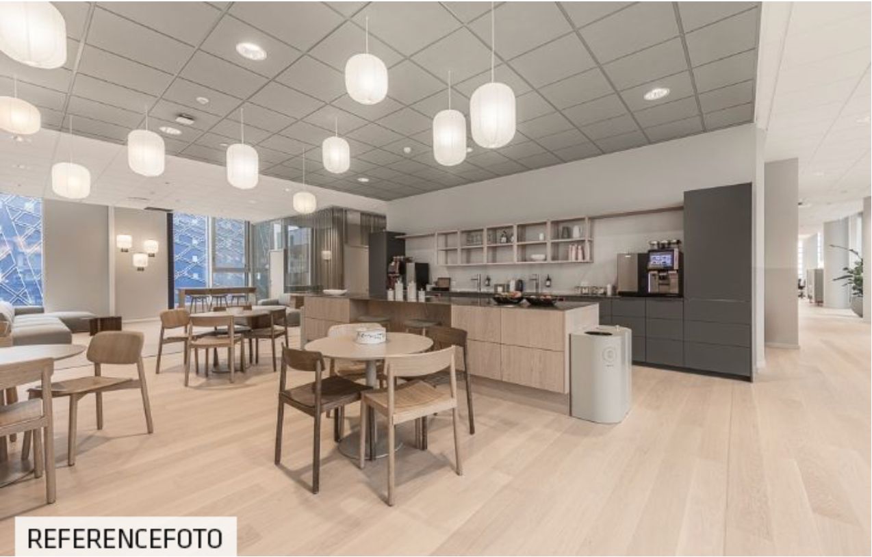 Moderne, lyse og veludstyret kontor med rundt bord, stole og køkken med strygejern og kaffemaskine