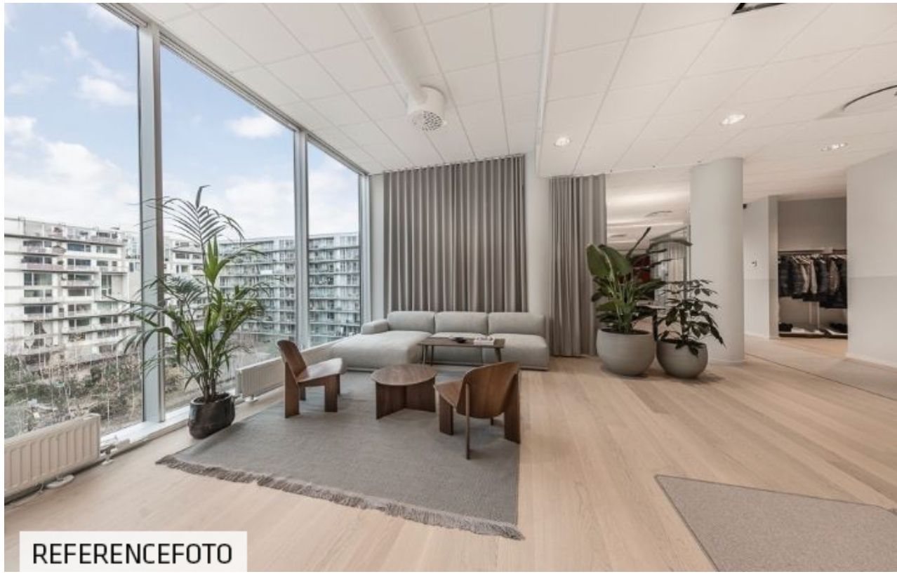 Kontorlokaler med udsigt til Amager Fælled, lyse gulve, moderne møbler og store vinduer med solskin
