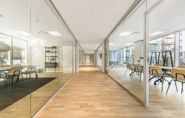 En luksuriøs, moderne kontorhøjbygning med glasvægge, højloft, og moderne møbler.