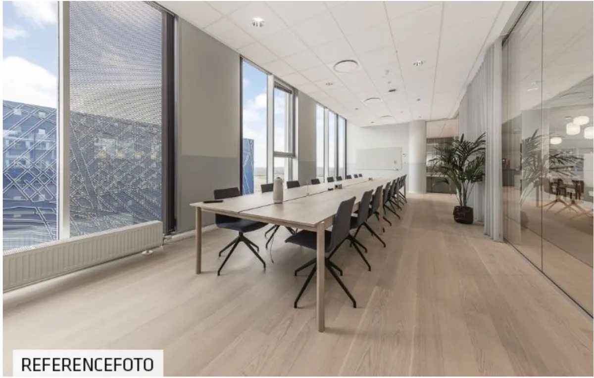 Stort kontor med glasvægge og massivt bord, flere stole og luftrensningsanlæg, møbelfrit rum og eksklusiv udsigt til Amager