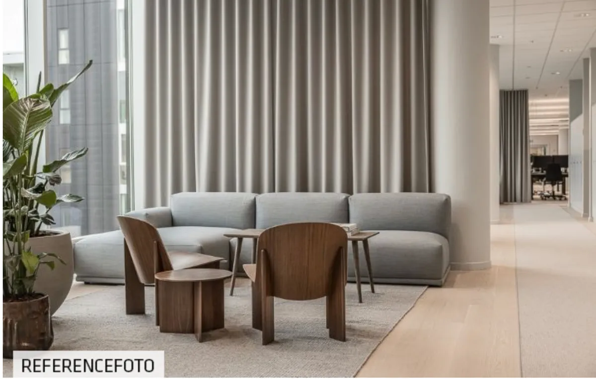 Moderne kontor med lyse, rummelige områder og naturligt lys. Komfortabel sofa, træstole og høj kvalitet møbler.