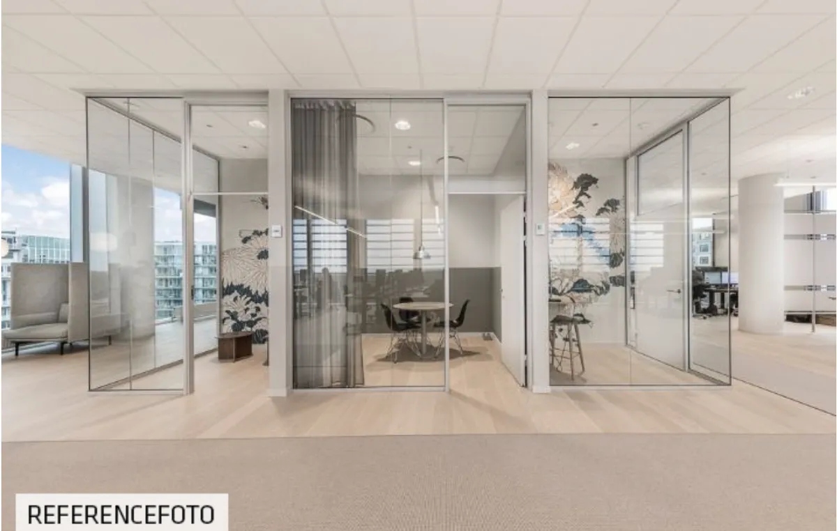 Moderne kontor med glasvægge og trægulv. Rundt bord og stole i mødelokale med udsigt til byen. Elegante møbler og dekorative