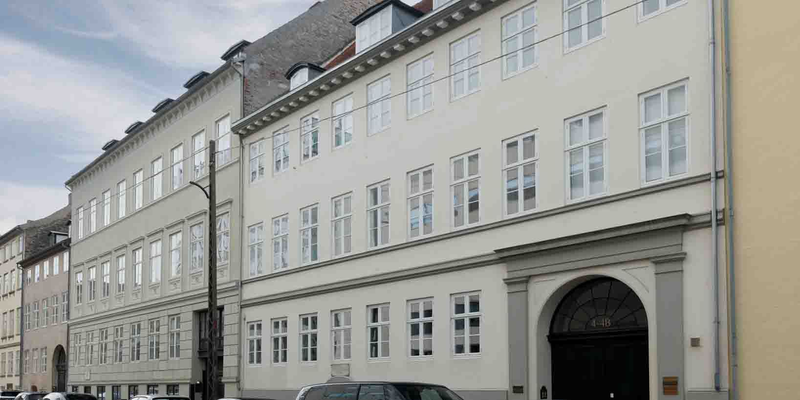 Lejemål med tre indgange og mange vinduer på en stor bygning i København