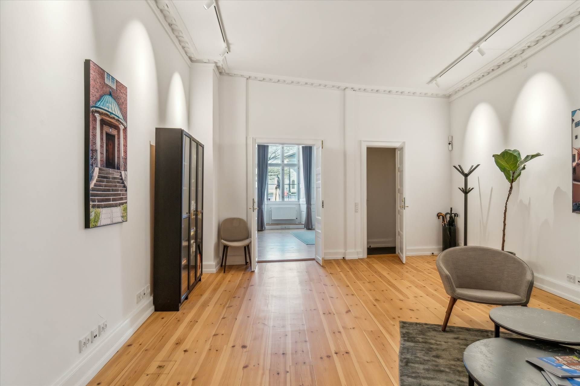 En stor, pænt indrettet stue med højkvalitets plankegulve og en stor stol med et bord i hjørnet