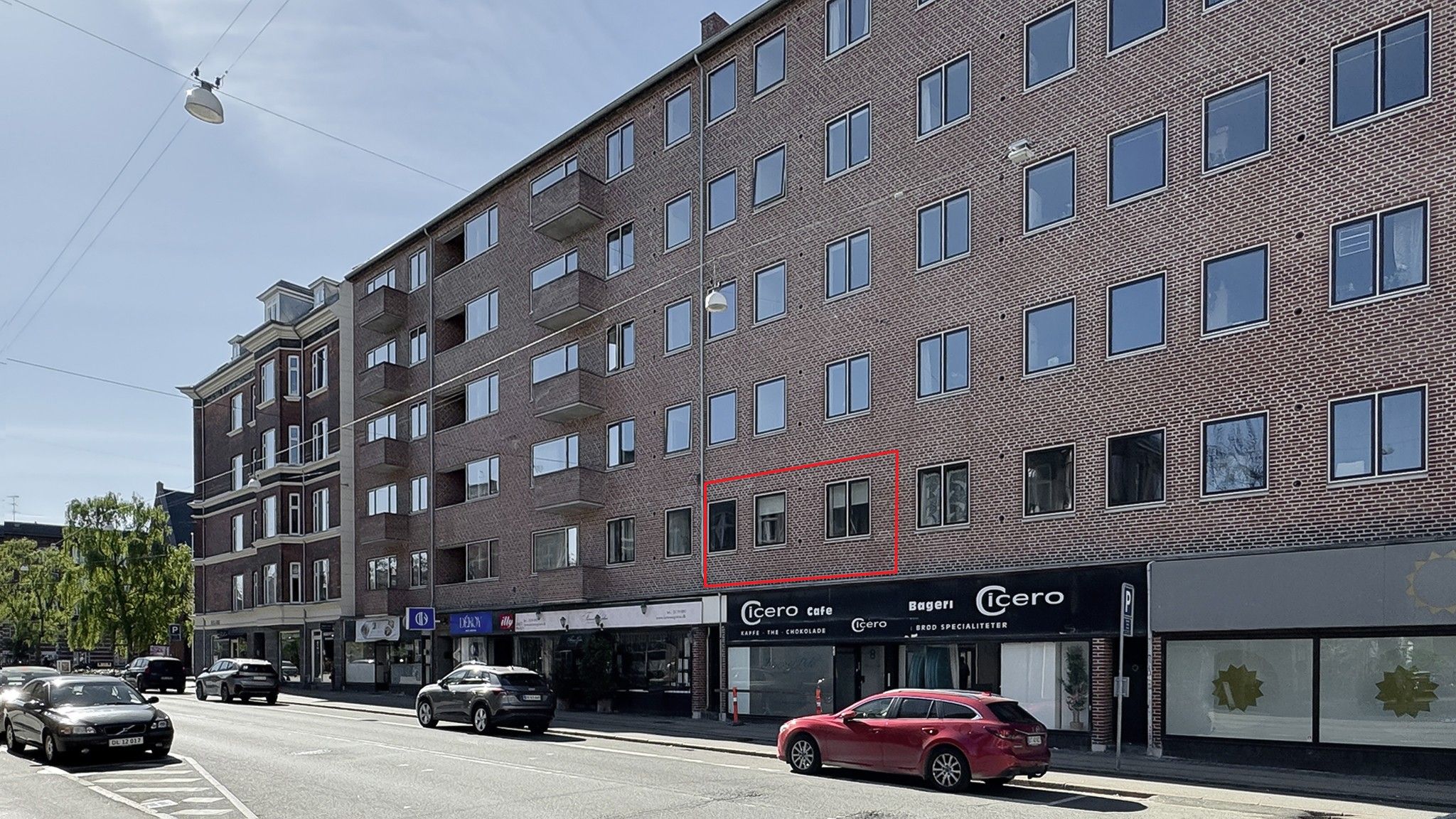 Store lejlighedsbygning med mange vinduer og en cafe med navnet Icero på første sal