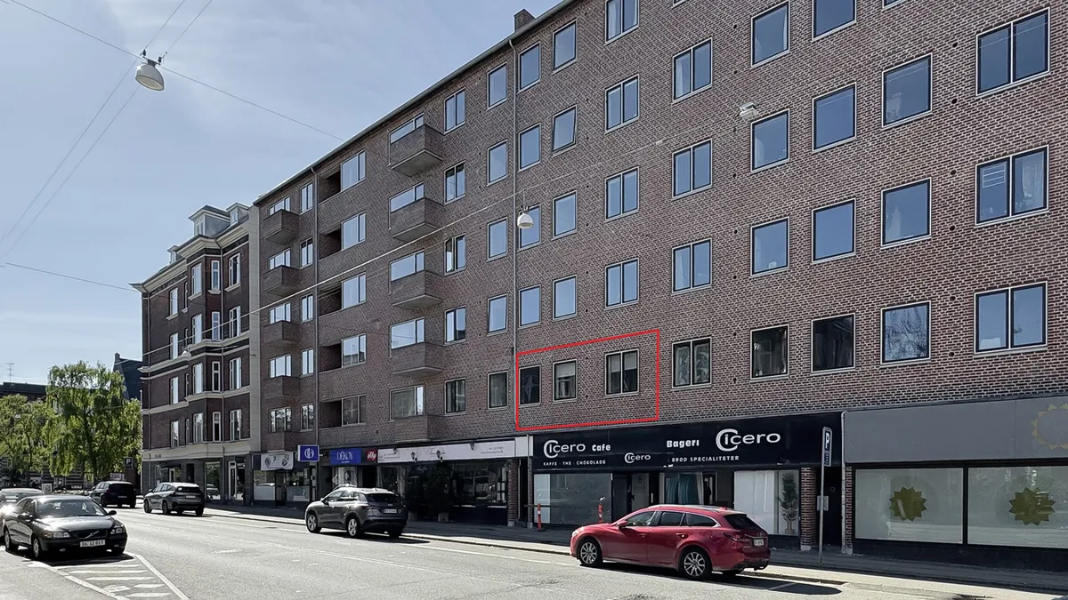 Store lejlighedsbygning med mange vinduer og en cafe med navnet Icero på første sal