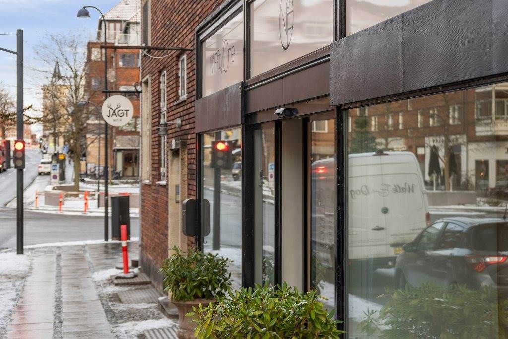 Et sted med et skilt med navnet Jagt på Gentoftegade og et rødt stoplys. En hvid varevogn og en bil er parkeret i gaden. Et