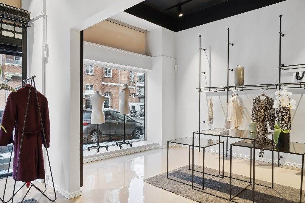 Et elegant indretningsmøbelforretning med moderne møbler og smukke blomster i sort og hvid farve. På højre side er der en