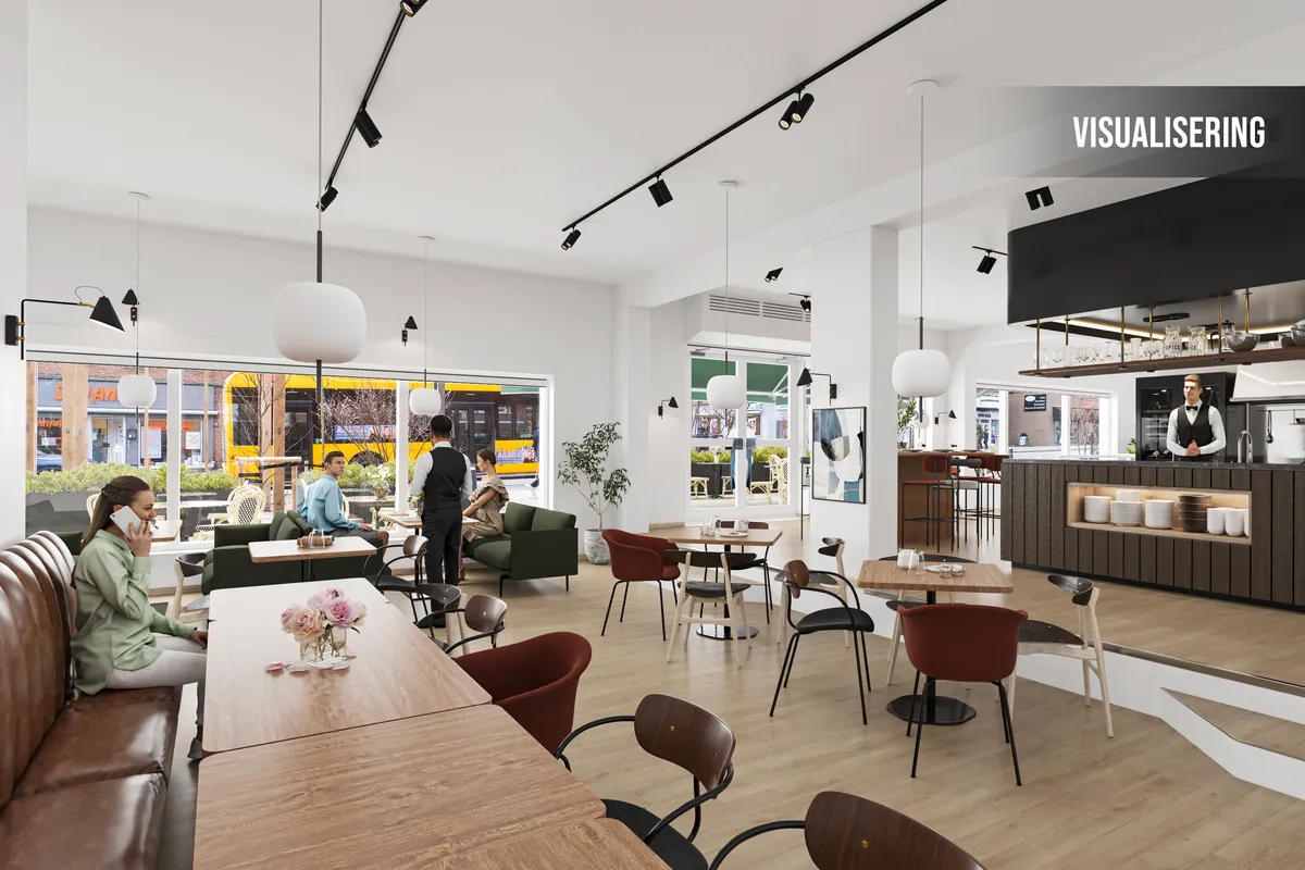 Et rummeligt cafélejemål med flere borde og stole og en kunde på telefon og en servitrice bag disken