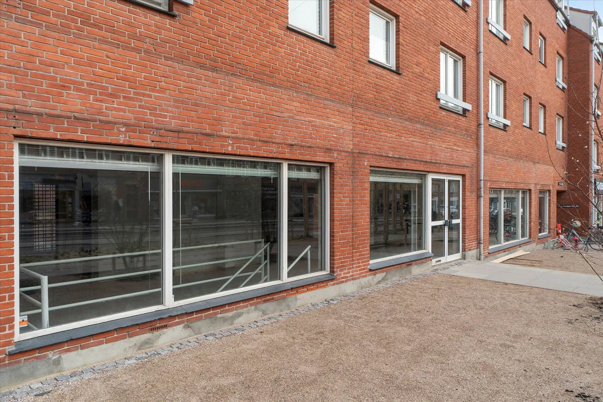 Lejlighed med store vinduer og gulvbelægning udenfor på Søborg Hovedgade. Rådgivende bygning med røde mursten og glasdøre og