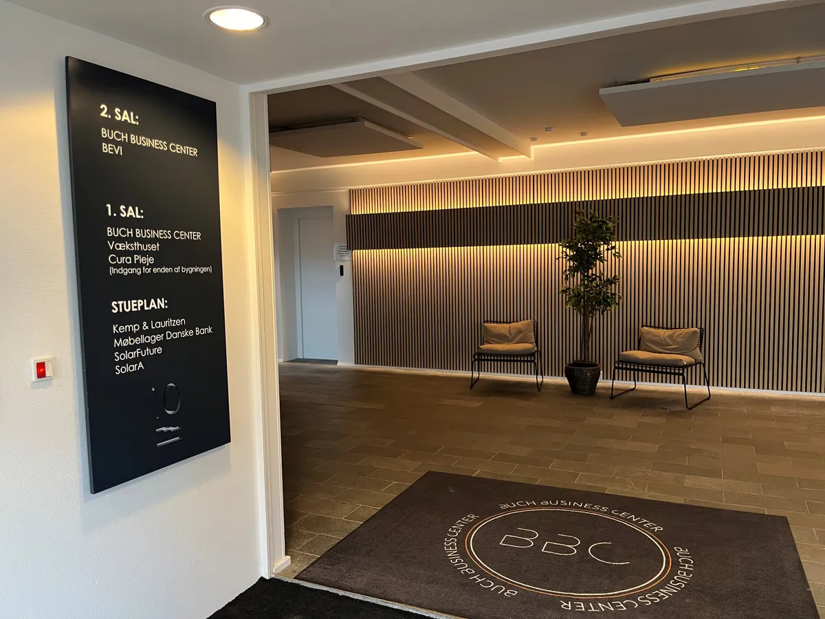 Lobby med gulv, møbler, væg og gulvtæppe, der læser Buch Business Center og BBC