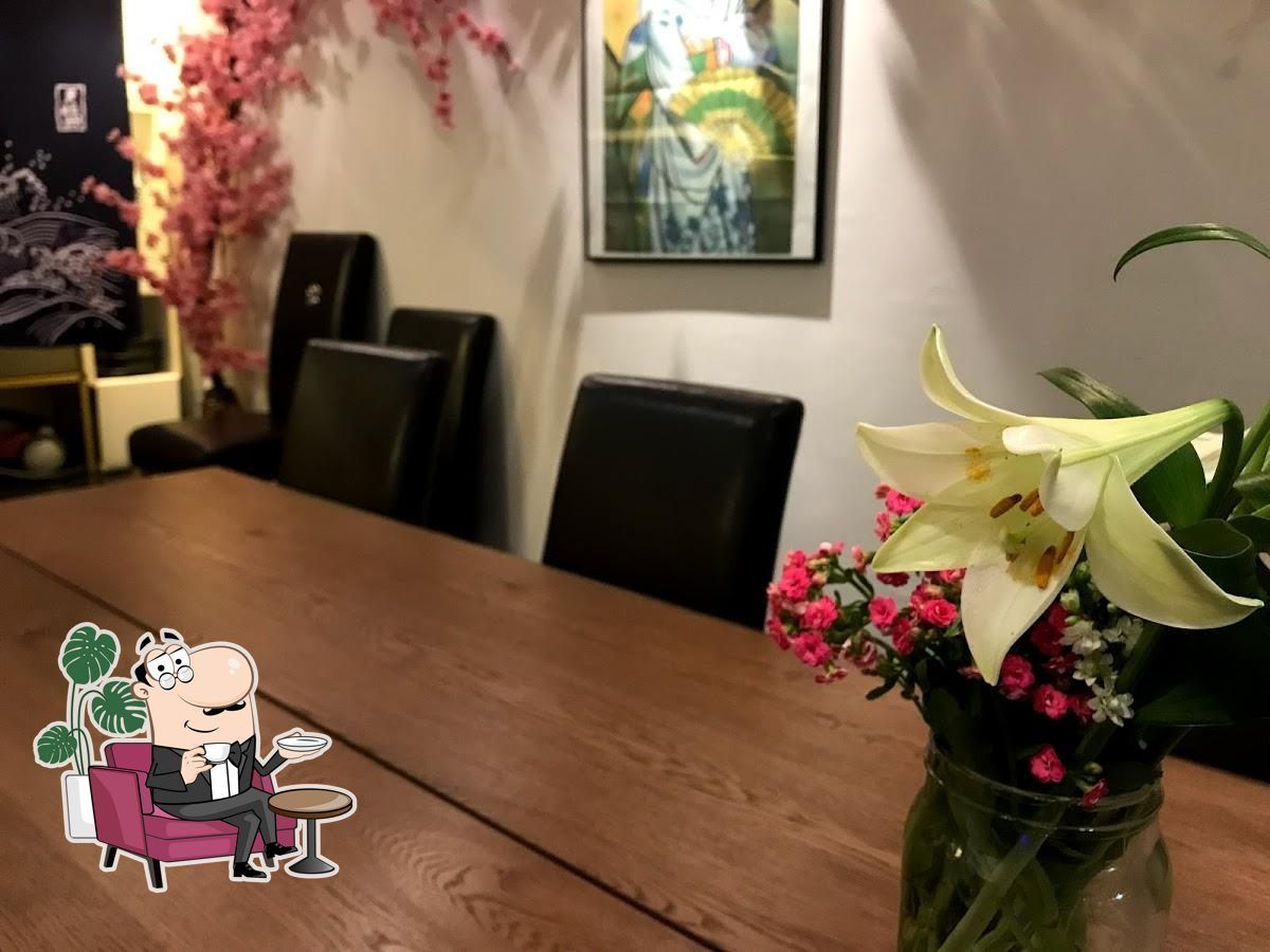 En træbord med en vase med blomster, en maleri og to lænestol i en elegant indretning