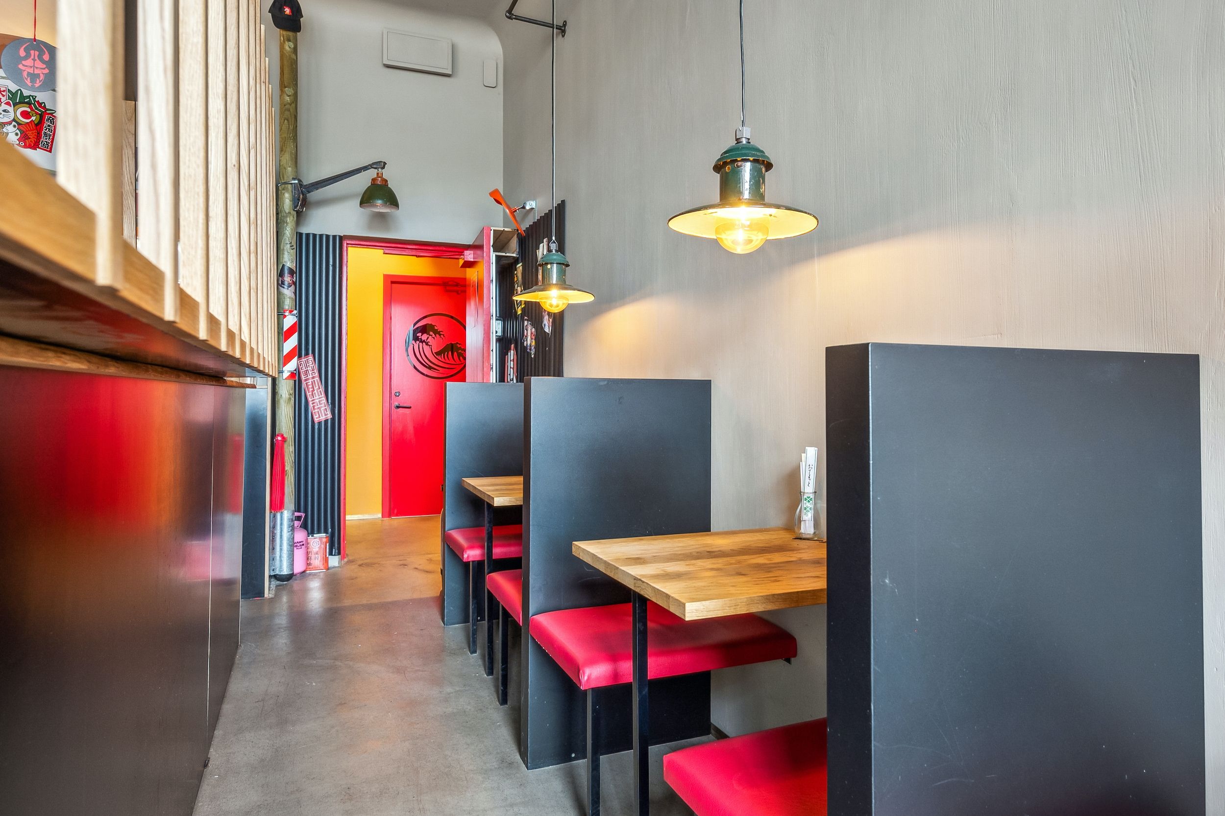 Slanke røde stolene omkring borde i restauranten med gule loftslampe og hvide vægge