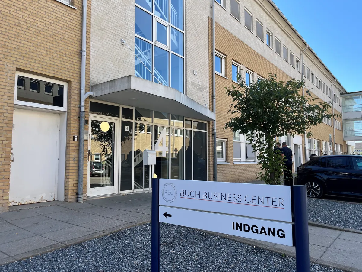BUCH BUSINESS CENTER indgang til kontorer i et moderne kontorfællesskab med glasdøre og en skjoldskilt med teksten INDGANG