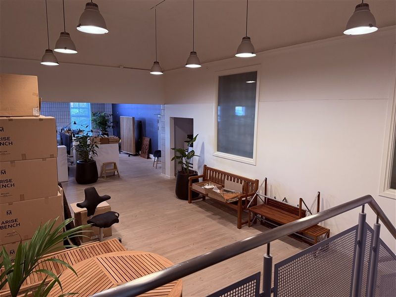 Rummelig kontor med højt til loftet og lyse gulvbelægning samt møbler og planter til landskabspleje