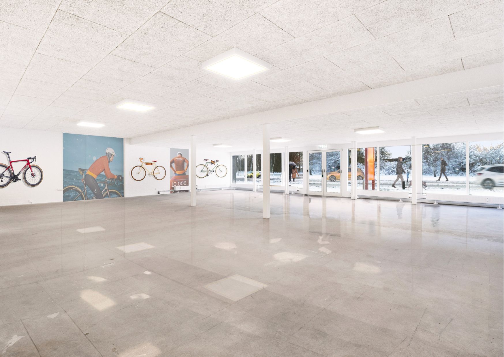 Inden i butikslokaler med lyse lofter og udsmykning på væggen med cykler og folk på vejen udenfor