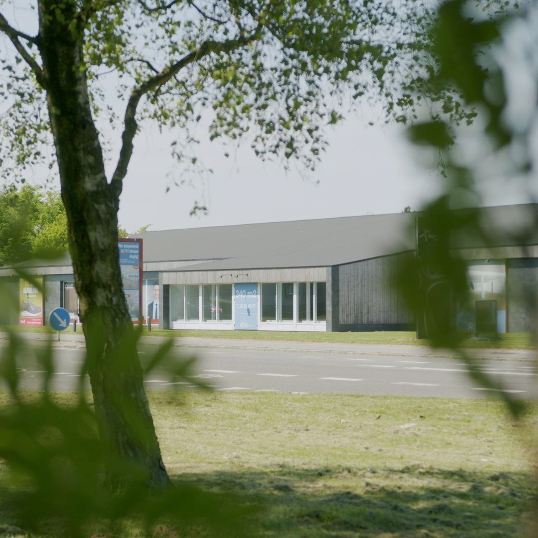 Et butikslokale med en stor plakat og vinduer, der viser en mand i en skjorte og slips