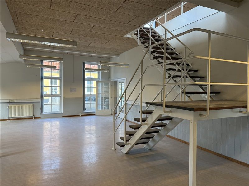 Kontor i Hedehusene med lyse lofter og vinduer mod gaden. Stiger og møbler i moderne stil