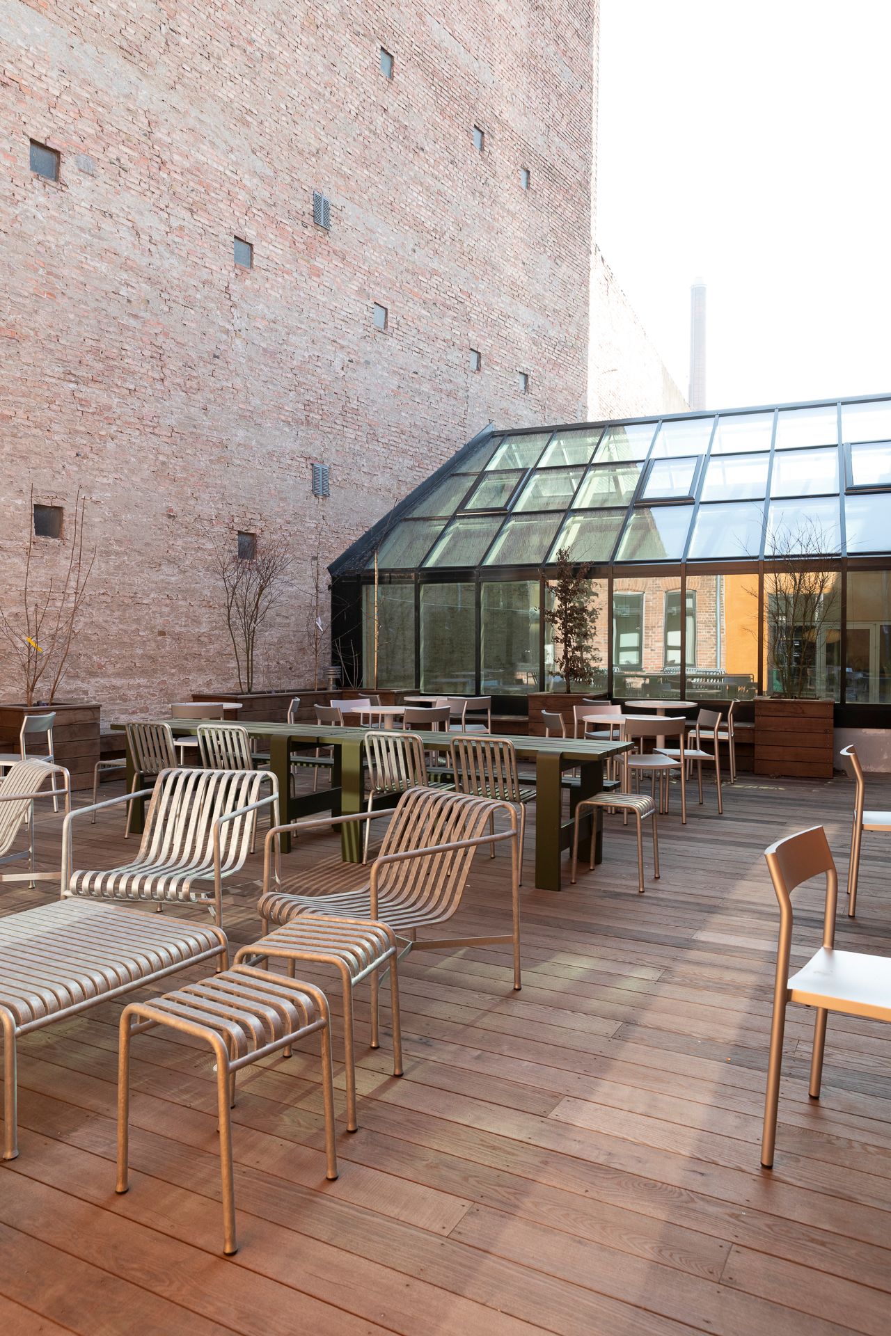 Moderne kontorfællesskab med lyse, glaskla vinduer og trægulve samt møbler af metal med sædepolstret beklædning