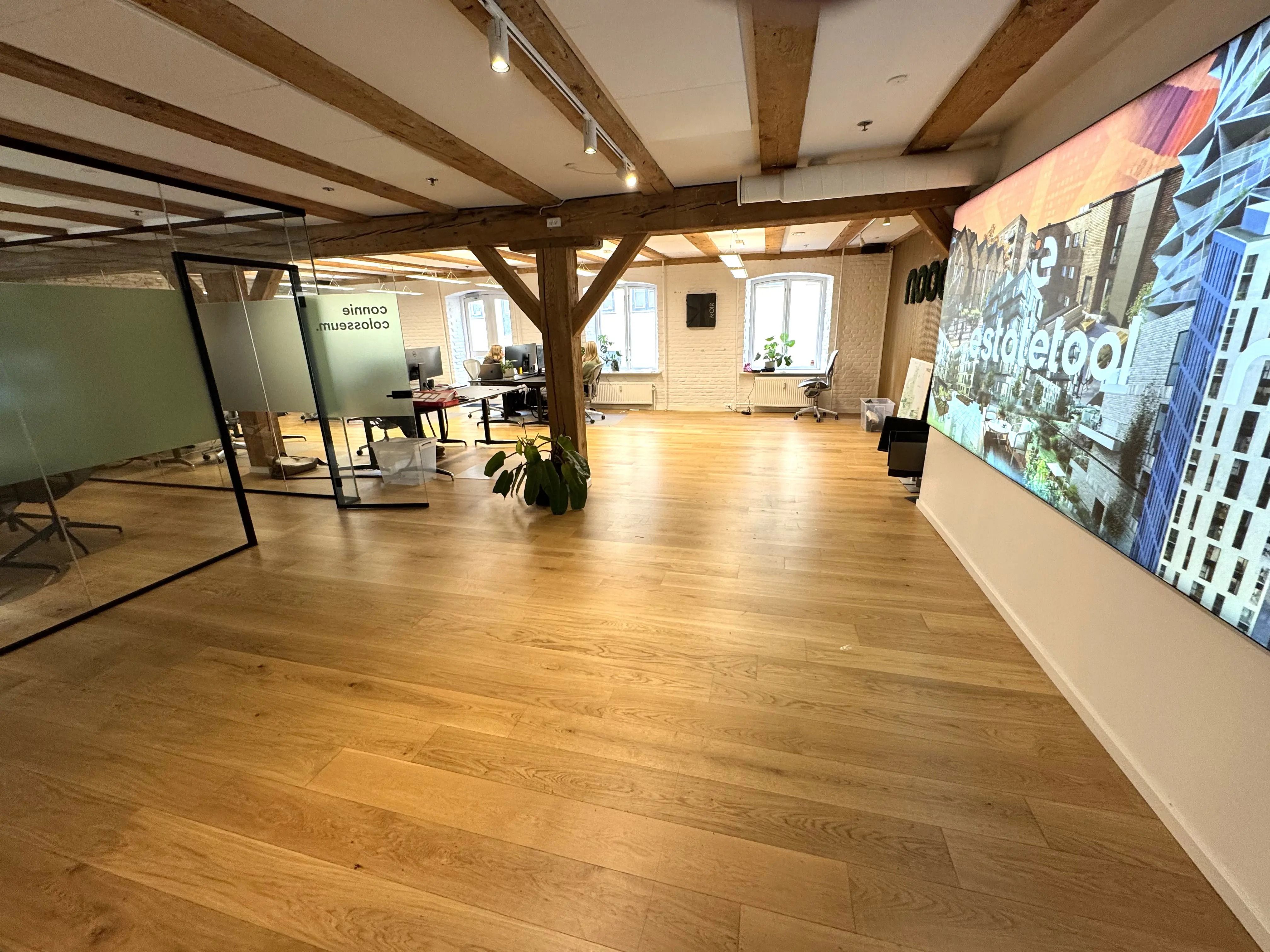 Ledig arbejdsplads med træloft og moderne møbler i kontorlokaler med udsigt til hovedgaden