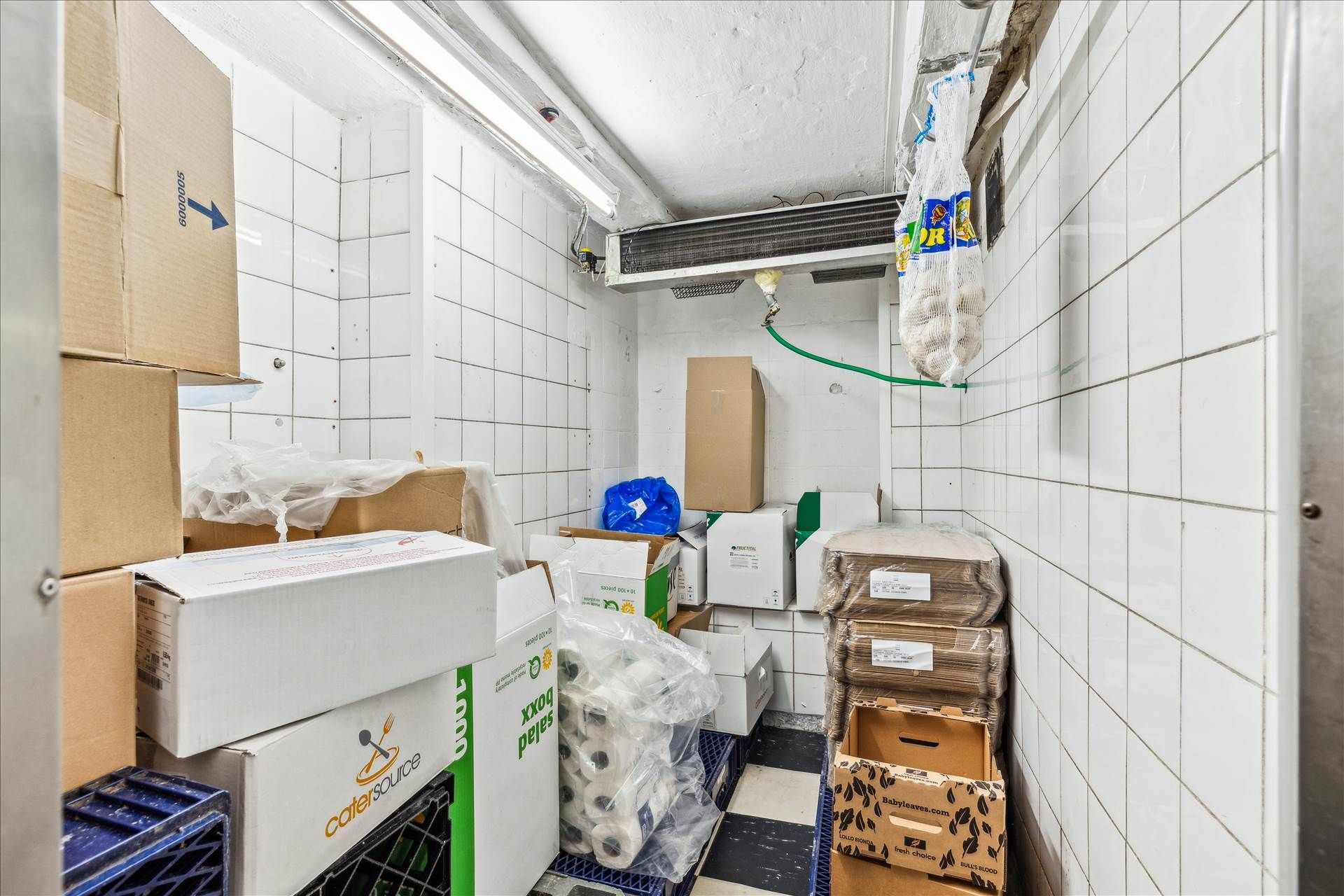 Lager med flere kasser og rullepapir samt opvaskede tøj i en ren og pænt indrettet stue