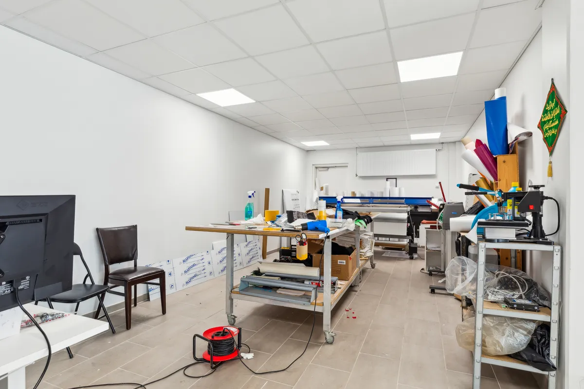 Inde i lokalet er der flere borde med diverse udstyr, herunder en printer og en svejsemaskine. Der er også en tv-skærm, to