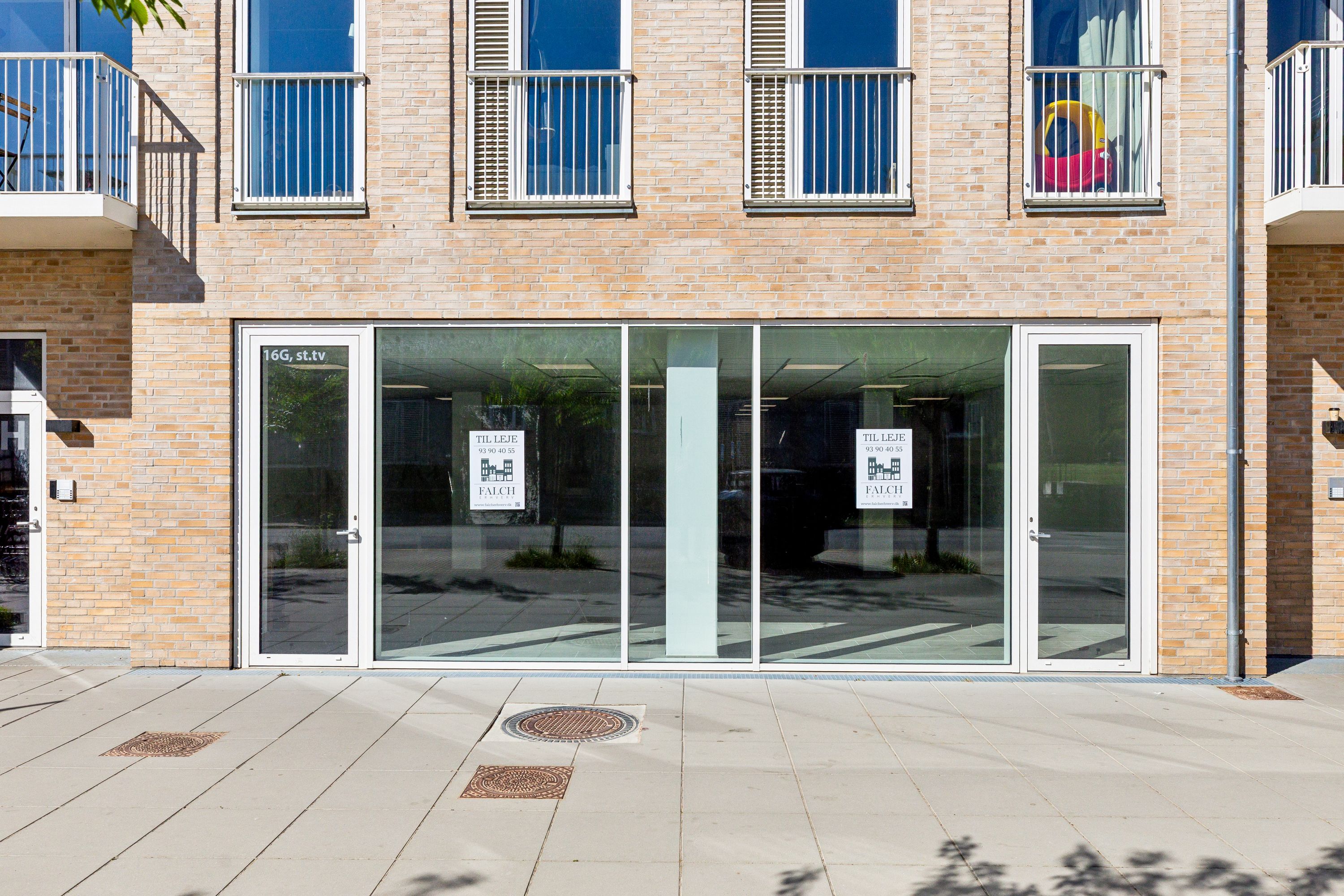 Lejemålet til detaljhandel og klinik i en ny bygning med en facade af røde mursten og store glasvinduer