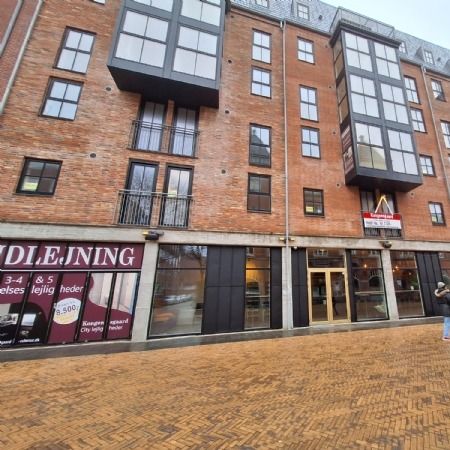 Kiosk med 3-4 værelser og 5 hedere lejes til 8.500 kr. månedlig i Odense. Person i jeanstøj og hættetrøje går forbi.