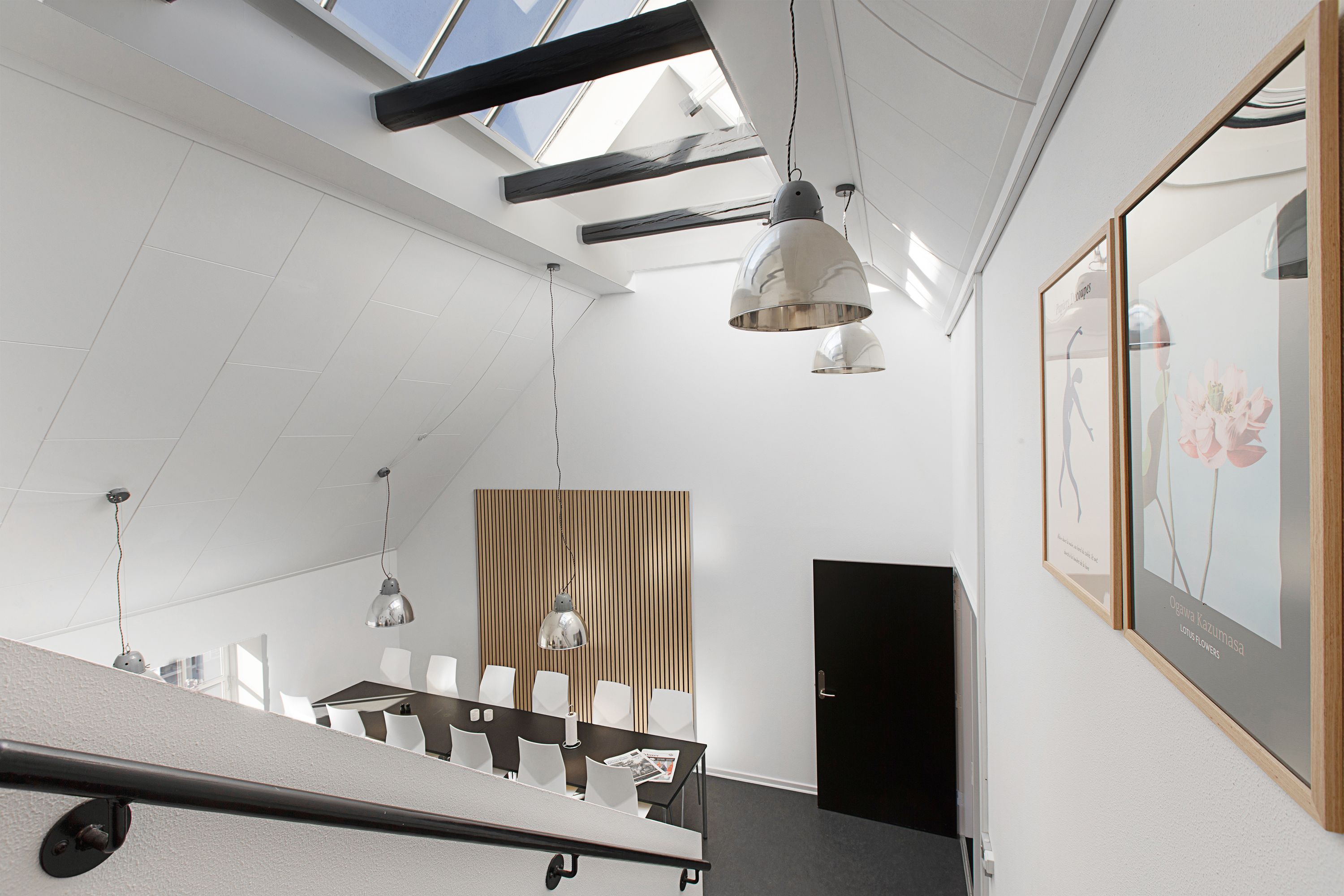 Kontorlokaler med møbler og loftsvinduer samt lysekroner og vægbilleder