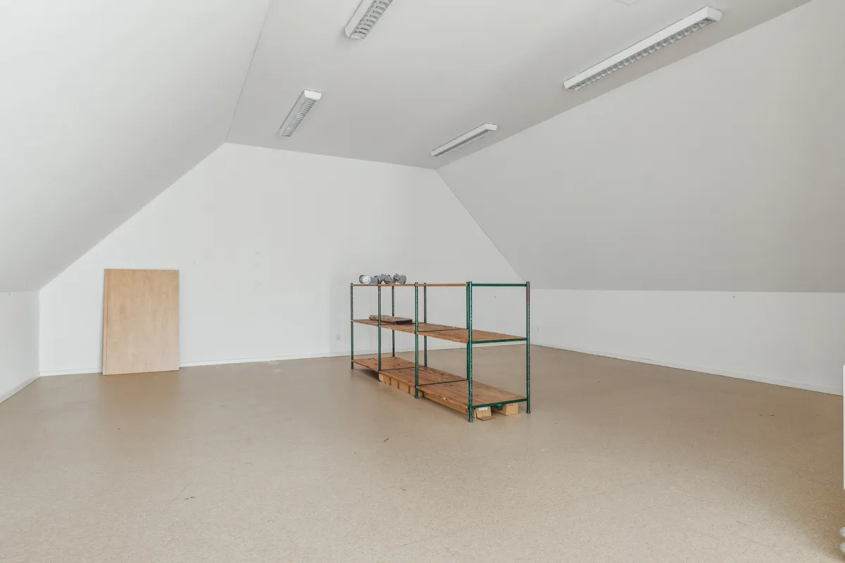 Et tomt værelse med hvide vægge og loft samt en stor gulvfladeskab og en åben dør