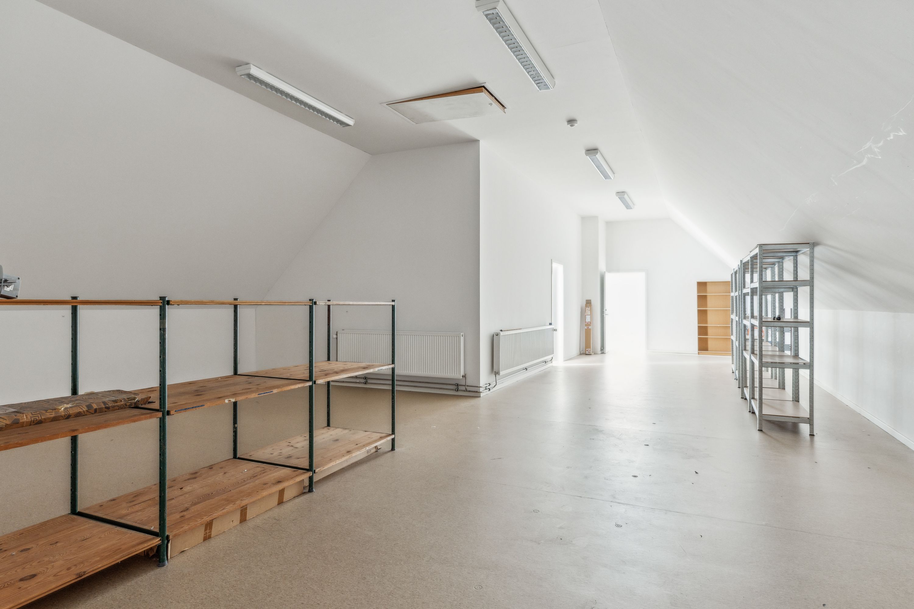 Kontor med to lyse lofter og højdepunkter, hvilket skaber et rummeligt og vellyst indtryk