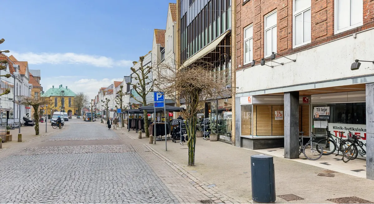Allerede nu er der solrige dage med fodgængere og cyklister på en ensrettet gade med forretninger og butikker