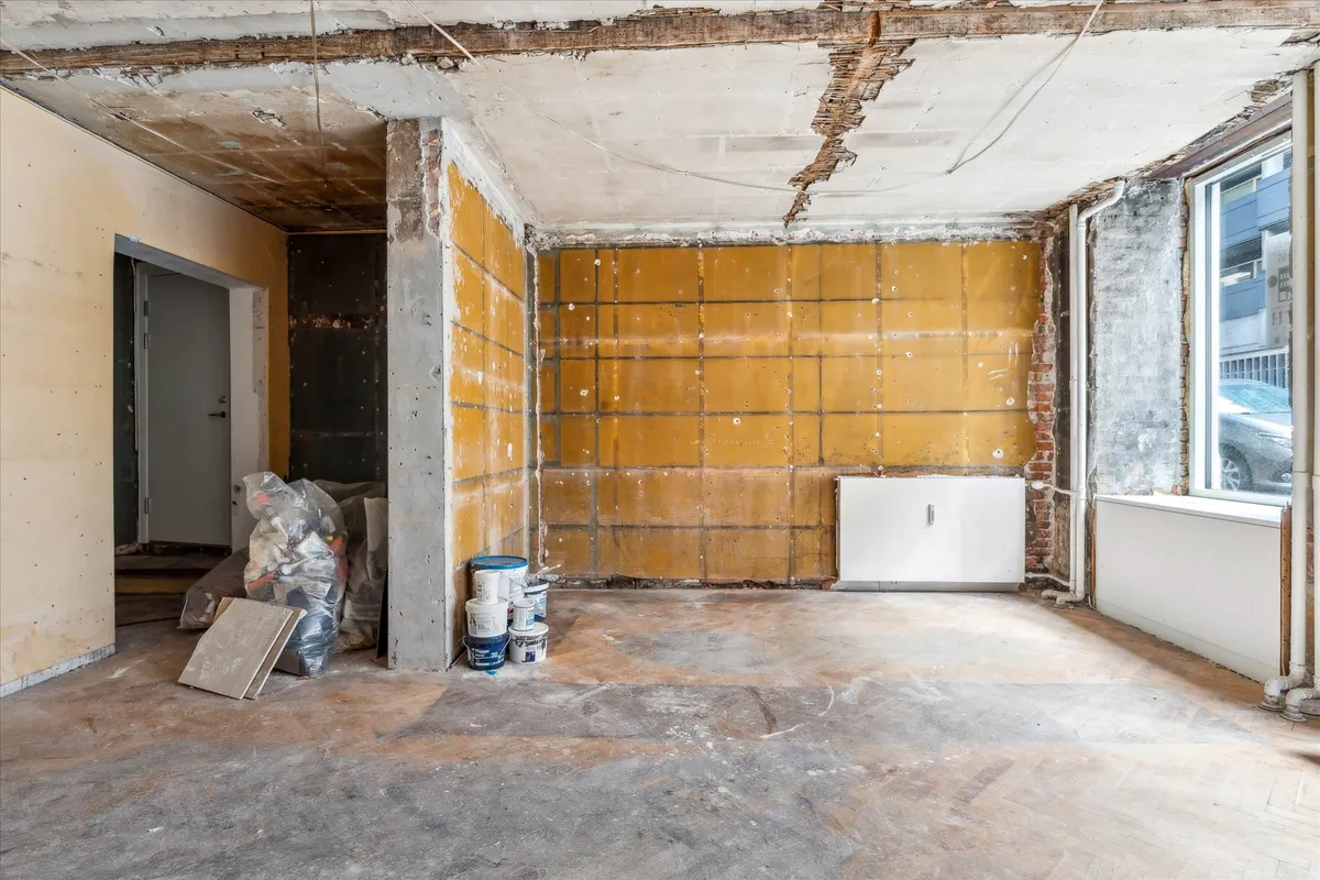 Råt og fleksibelt erhvervslejemål på Nørrebro med 112 m² og 100 m² kælder, hvor vægge er revet og gulv dækket af støv og
