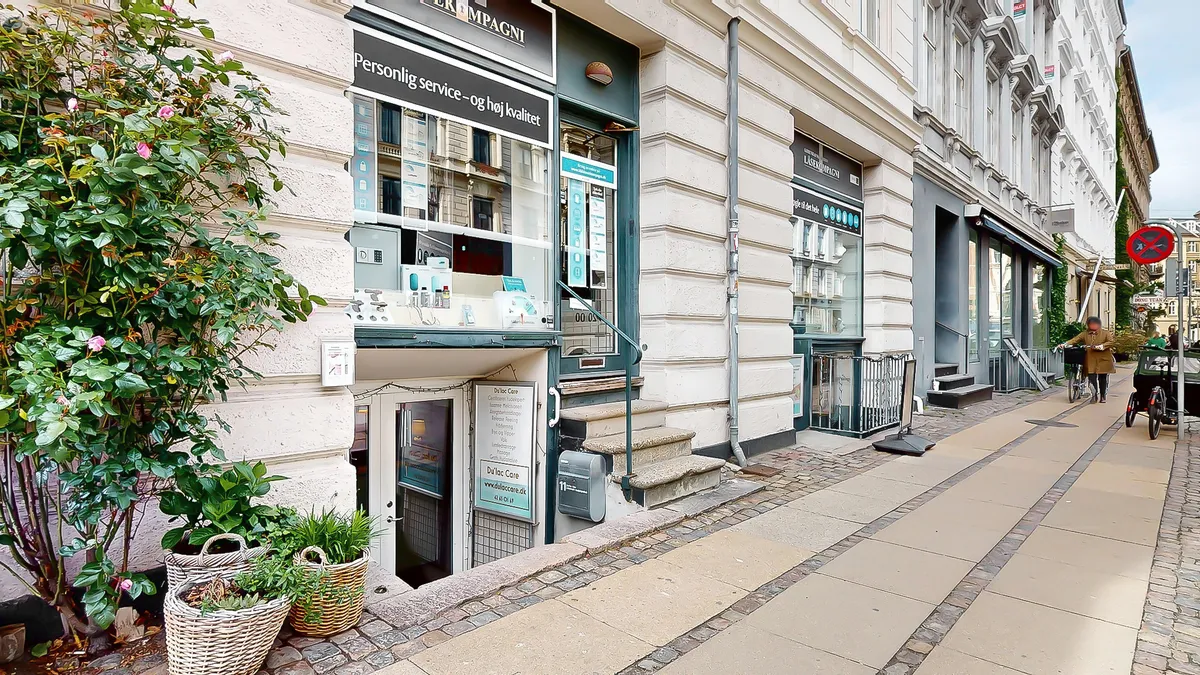 Butik med skrifterne Personlig service og høj kvalitet og Du Lac Care på søjle. Stiger og trapper fører op til butikken. En