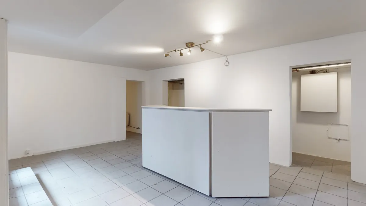 Rent, tomt kontorrum med hvide vægge og gulv, lysekroner, skraldespand og teknisk indretning